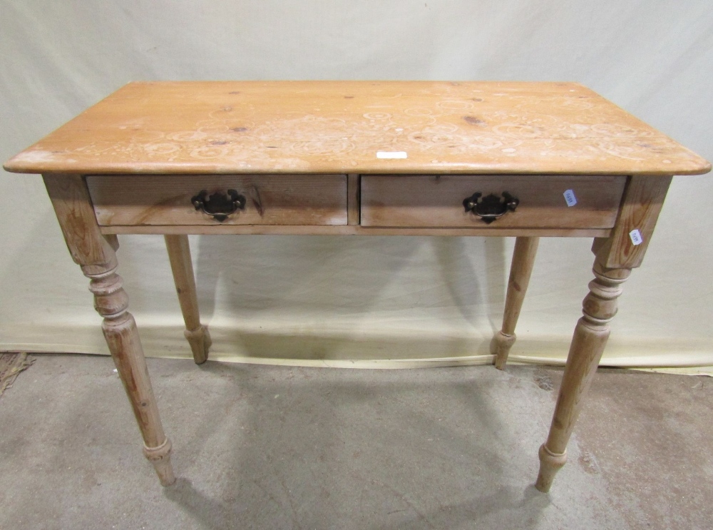 A Victorian stripped pine side table fitted with two shallow frieze drawers raised on turned tapered