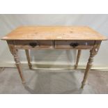 A Victorian stripped pine side table fitted with two shallow frieze drawers raised on turned tapered