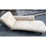 A Victorian chaise lounge with shaped outline and upholstered finish raised on turned legs and brown