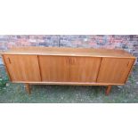 Danish retro teak long and low sideboard enclosed by four sliding doors, the interior segmented and