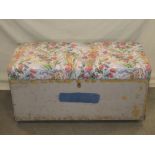 A vintage painted pine trunk with upholstered hinged lid and flush fitting carrying handles with