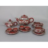 A collection of oriental terracotta teawares with white metal overlay in the form of dragons,