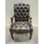 A reproduction Georgian style buttoned green leather upholstered open armchair, loosely in the