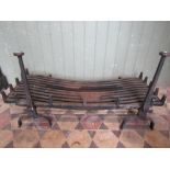A wide cast iron cast iron fire grate/basket and loose andirons, with tapered stems and flattened