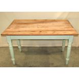 An old pine kitchen table, the rectangular scrub top raised on a green painted base with frieze