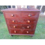 A Victorian stained pine bedroom chest of two short over three long graduated drawers flanked by