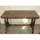 A Victorian oak library table of rectangular form with moulded outline and raised on four turned