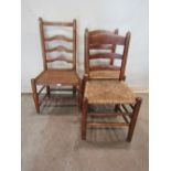 A pair of 19th century country made stained elm and ashwood ladderback dining chairs with rush seats