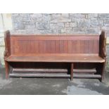 A pitch pine church pew with plank seat and chamfered ends (each end with oval numbered disc), 80 cm