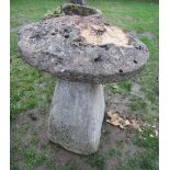 A natural stone staddlestone of square tapered form with stone cap