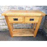 A contemporary light oak sideboard fitted with two frieze drawers, raised on square cut supports,