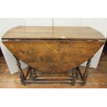 A small 18th century oak gateleg table of good colour on turned supports, enclosing a single