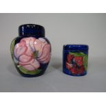 A Moorcroft blue ground cylindrical jar and cover with red hibiscus decoration, with impressed