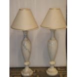 A pair of white and grey veined vase shaped alabaster table lamps with drawn necks, moulded stems