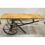 An early 20th century iron work water barrow frame/trolley with spoke wheels, later adapted with oak