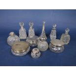 A collection of silver and glass dressing set items, comprising four silver topped powder jars and 7