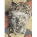 A weathered composition stone wall mounted face mask 32 cm in height