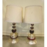 A pair of substantial polished wood and light metal table lamps with knopped stems and flared