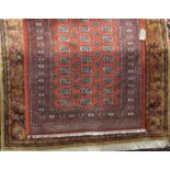 Bokhara full pile rug, with typical geometric decoration upon a burnt orange ground, 190 x 130cm