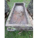 A shallow rough hewn natural stone trough of rectangular form, approx 115cm long x 50cm wide x