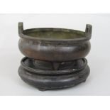 Antique Chinese cast bronze twin handled sensor upon three feet, calligraphy mark to base, 15cm
