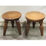 A pair of elm milking type stools with circular seats raised on turned splayed legs