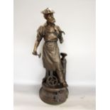 Cast bronzed spelter character group in the form of a rugged gentleman in overalls and a flat cap,