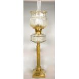 A brass table standing oil lamp, the reeded column on a stepped frame with moulded glass font,