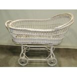 A wicker pram with painted finish and wire spoke wheels