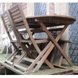 A contemporary weathered teak garden table with oval slatted top raised on folding x framed