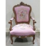 A 19th century open armchair with floral tapestry upholstered seat, within a carved walnut frame,