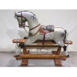 An Edwardian dapple grey rocking horse by F H Ayres, raised on a turned stretcher frame with