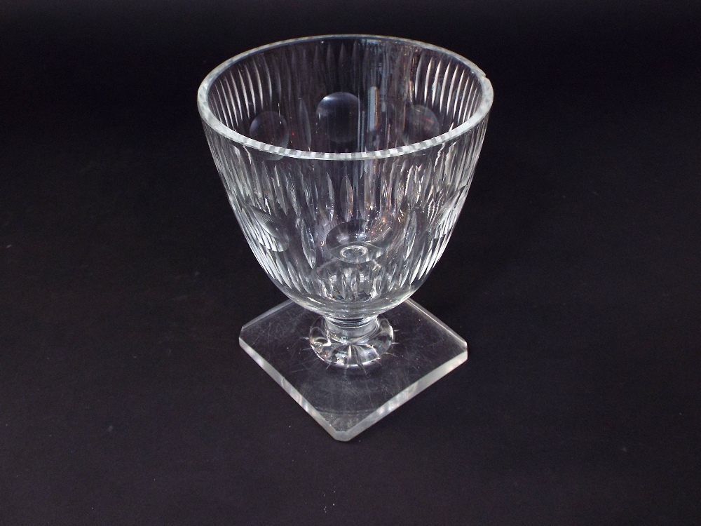 A 19th century cut glass vase with faceted decoration raised on a square cut base, 16 cm tall