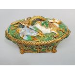 A 19th century Minton majolica two handled game dish and cover, the base modelled as a basket with