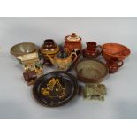 A collection of studio pottery wares including a brown glazed dish with slip decoration of a dove,