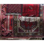 Middle Eastern rug decorated with various medallions upon a red ground together with a similar green