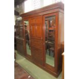 A good quality inlaid Edwardian mahogany triple compactum wardrobe enclosed by an arrangement of