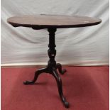 A Georgian mahogany snap top table, the circular top raised on a vase shaped pillar and tripod base,