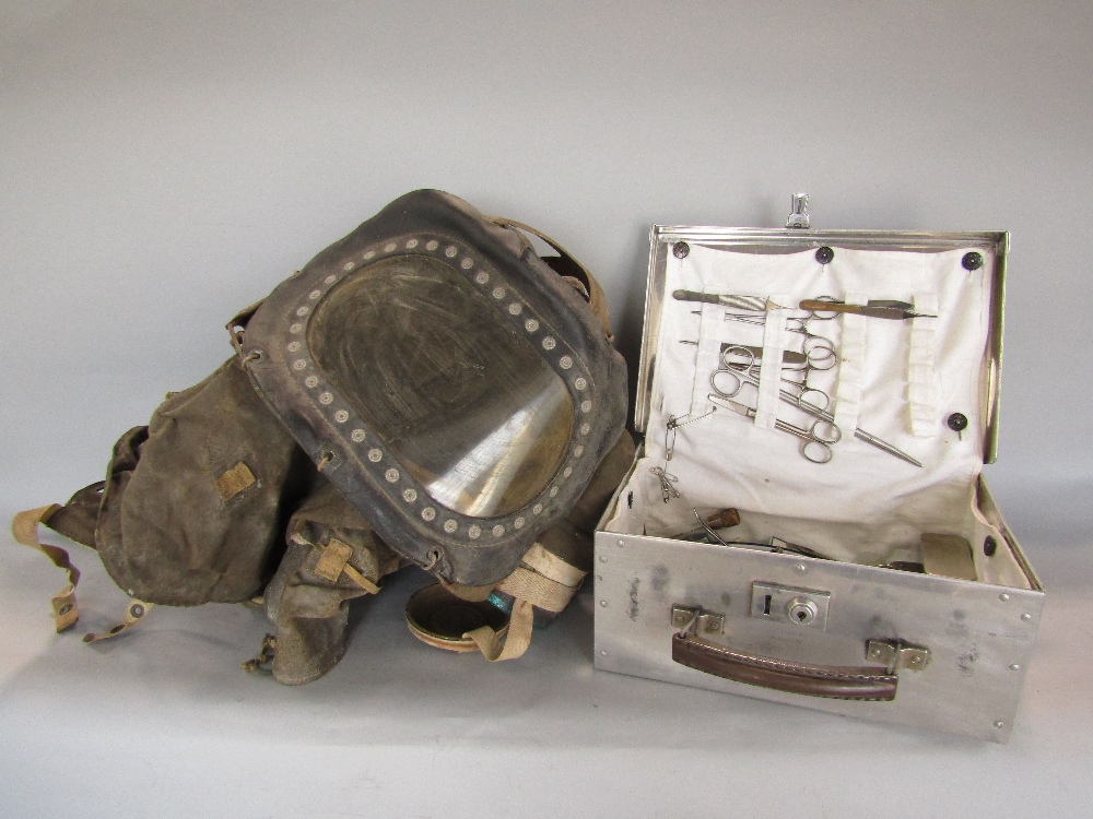 A World War II child's gas mask, aluminium first aid kit and contents