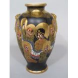 A late 19th century Satsuma vase of lobed form with painted and gilded multiple face and wrythen