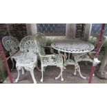 A cream painted cast aluminium garden terrace table of circular form with decorative pierced detail,