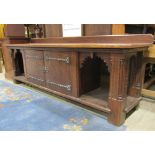 A substantial antique Gothic oak sideboard, partially enclosed by a pair of rectangular doors,