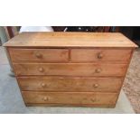 A large Victorian stripped and waxed pine bedroom chest of two short over three long drawers, one of