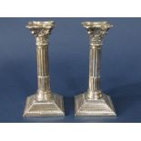 Pair of silver Corinthian column candlesticks upon stepped square vases, maker AS, Birmingham