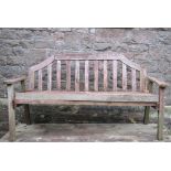 A Swan Hattersley weathered teak garden bench with slatted seat and back beneath a shaped rail, (