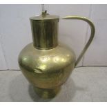 A large hammered brassware ewer, with drawn neck and loop handle, complete with cover
