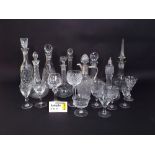 A collection of decanters and stoppers of various form with cut and faceted detail, together with