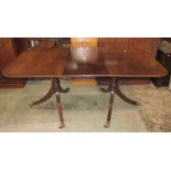 A reproduction Regency style twin pillar dining table with two additional leaves, reeded detail,
