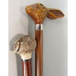 A walking cane, the knop in the form of a hares head, another with a badger mount (both resin)