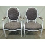 A pair of open armchairs with upholstered seats and cameo shaped backs within painted frames with